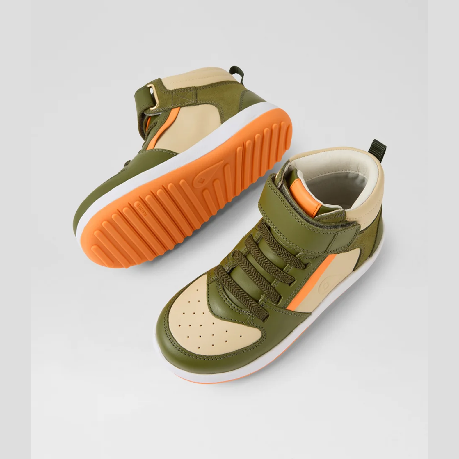 Pair of green and beige high-top sneakers with orange soles on a light gray background